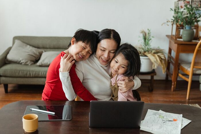 A mother embracing two children, showcasing the complexities of gender roles and toxic femininity.