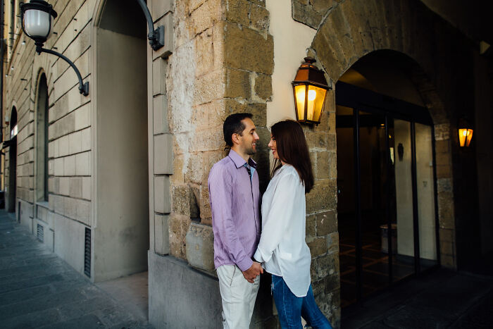 A couple holding hands by a stone wall, a brutal way for affairs to come to light.