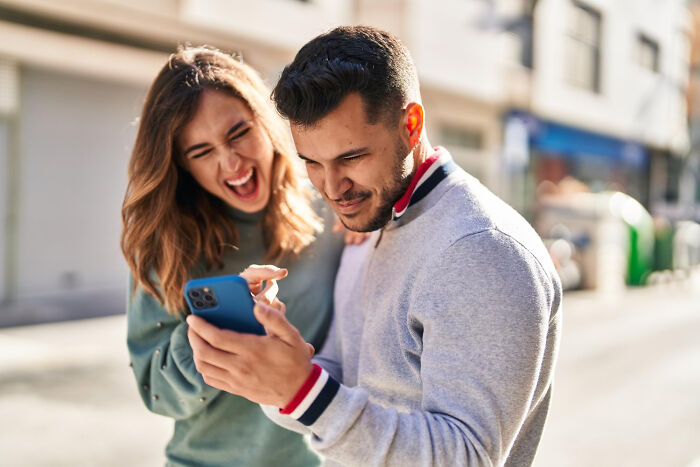 A couple looking at a phone together, uncovering affairs in a brutal way.