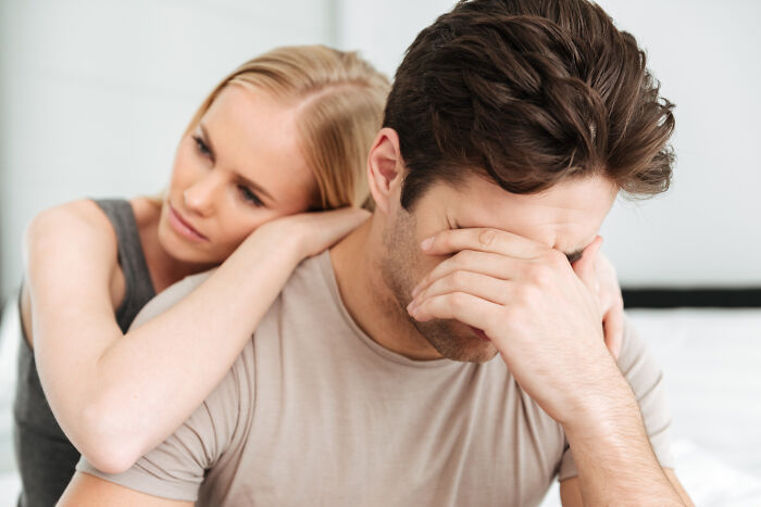 A woman comforts her partner, who covers his face in distress, as their affairs come to light in a brutal way.