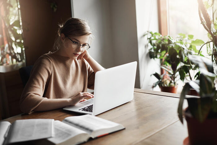 A woman works on a laptop, potentially discovering a partner's affairs in the most brutal way possible.