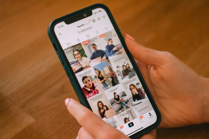 Hands hold a smartphone displaying social media, where affairs could brutally come to light for partners.