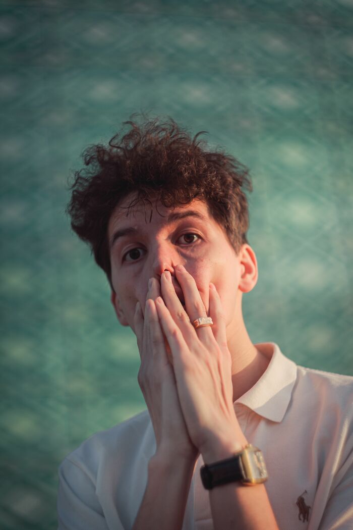 A man covers his mouth in shock, possibly realizing he's with the wrong person.
