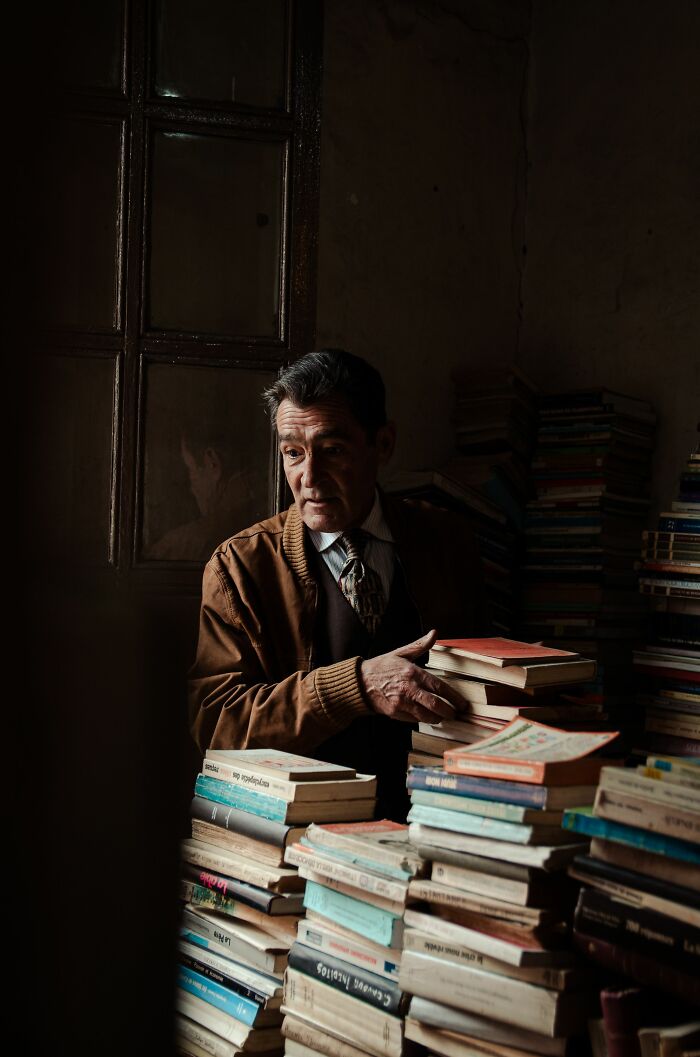 Elderly man surrounded by stacks of books, a scene that evokes the sick burns of lost knowledge.