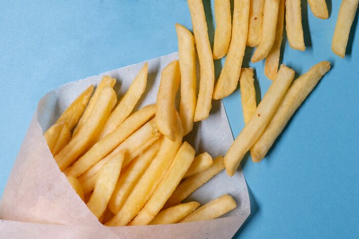 Crispy french fries spilling from a paper bag, imagining crazy things customers said at a drive-through.