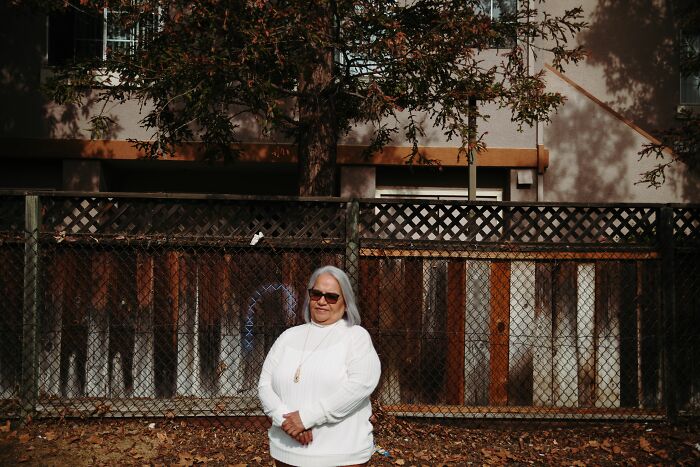 An older woman with white hair and sunglasses standing outdoors, showcasing the diversity of America.