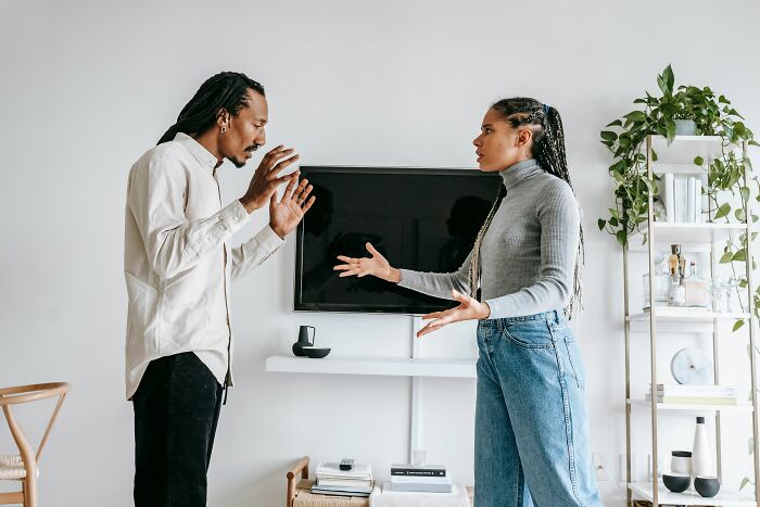 A couple arguing in their living room after the boyfriend said something hurtful.