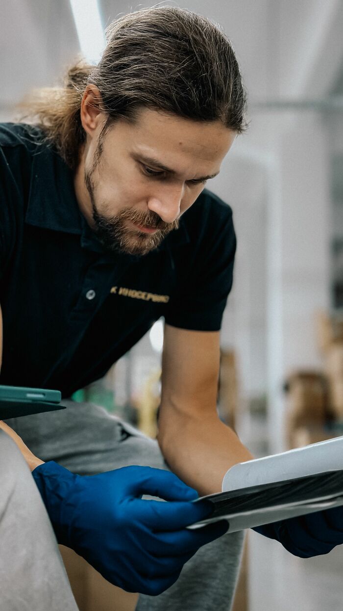 Man in gloves examines details, reflecting spicy personal details about coworkers.