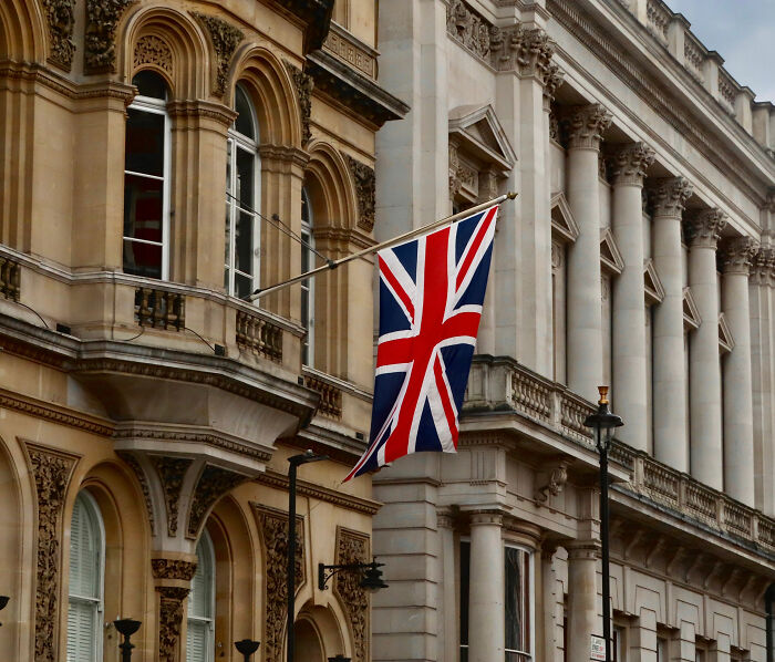The Union Jack flag flies over a building, symbolizing Prince Harry and Meghan Markle's move back to UK and related theories. The Union Jack flag flies over a building, symbolizing Prince Harry and Meghan Markle's move back to UK and related theories.