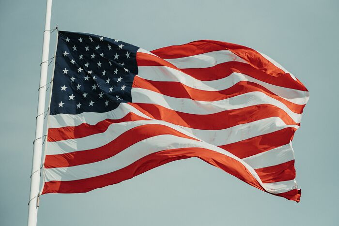 The American English flag waves against a clear sky, symbolizing the rich history and cultural influence of American English. The American English flag waves against a clear sky, symbolizing the rich history and cultural influence of American English.