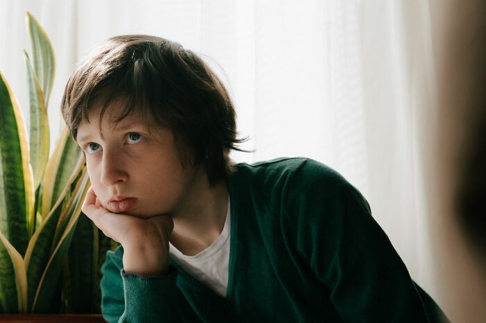 A young child looking off-camera, appearing bored or contemplative, highlighting what can make a parent horrible.