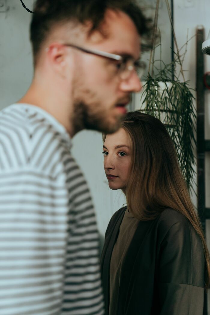 A woman looks over her shoulder at a man in the foreground, focusing on the exact moment her boyfriend said something.