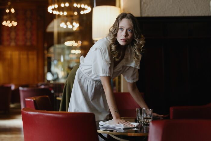 A waitress wiping a table, possibly a shocking employee story for HR pros about getting fired.