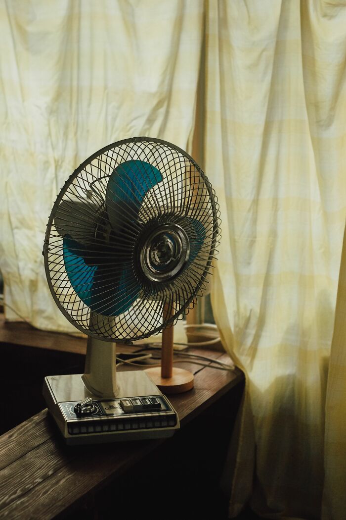 An old fan on a wooden shelf, representing outdated ideas or misconceptions that people still believe.