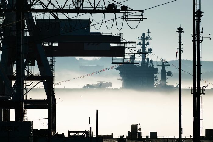 A large warship in the distance shrouded in fog, symbolizing the gravitas of shocking employee stories and their consequences.