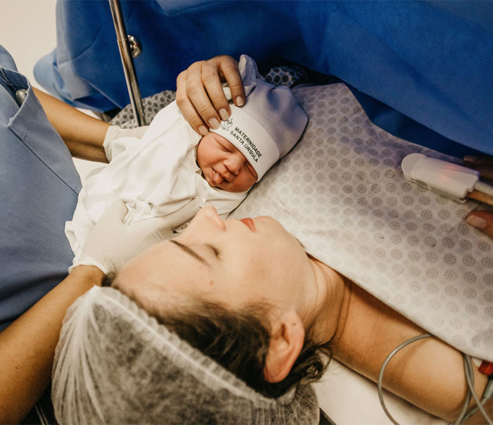 A new mom holds her newborn baby, reflecting on reasons for having kids and the brutal reality parents face. A new mom holds her newborn baby, reflecting on reasons for having kids and the brutal reality parents face.