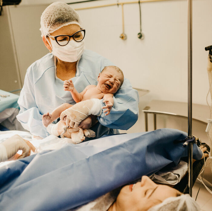 A nurse holding a newborn baby in a delivery room, relevant to accidental married cousin story. A nurse holding a newborn baby in a delivery room, relevant to accidental married cousin story.