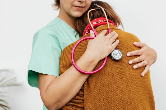 A medical field worker hugging a patient, showing the compassionate side of healthcare that workers want people to understand.