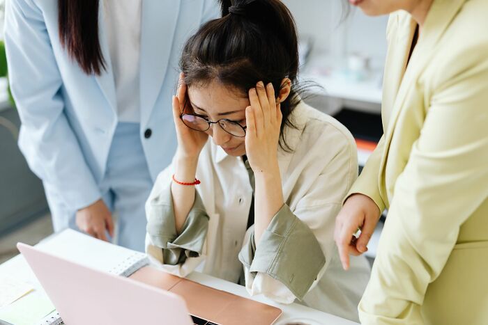 Employee stories where HR pros say workers were fired, showing a stressed employee at a laptop.