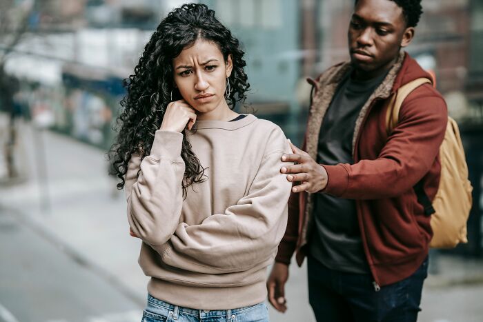 A woman looking upset while her boyfriend tries to comfort her, reflecting relationship challenges women face.