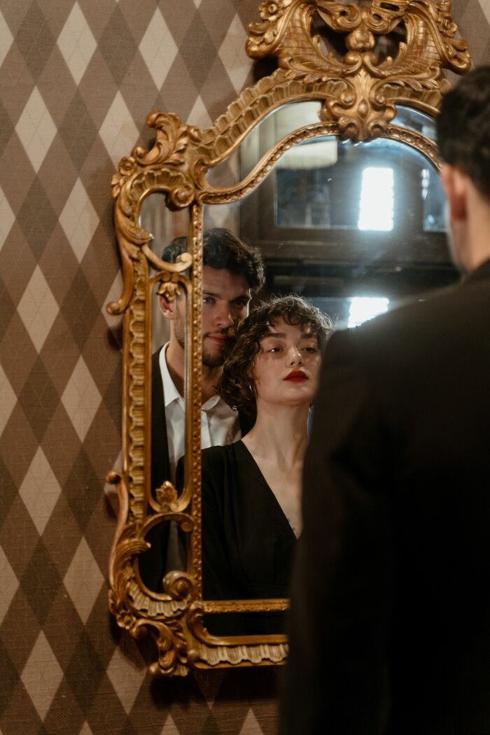 A woman and a man reflected in a mirror, conveying the moment their boyfriend said something they could never come back from.