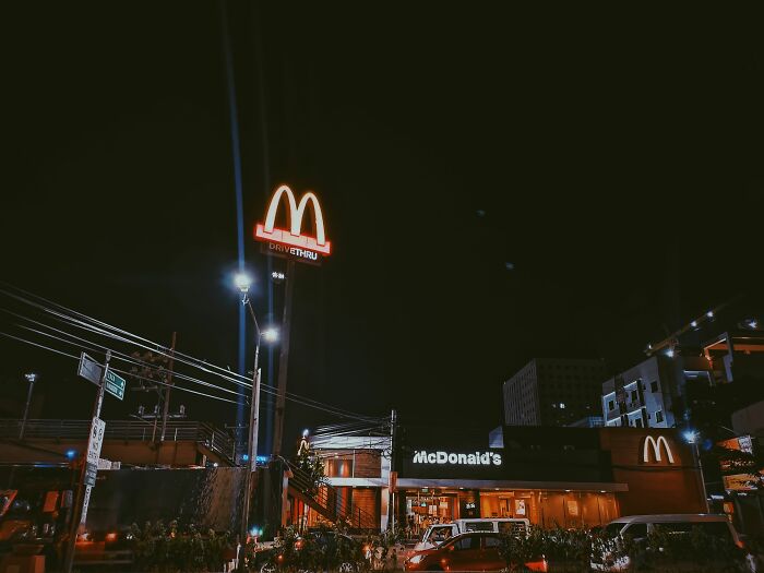 A McDonald's drive-through at night, showcasing a typical setting where customers interact with employees.