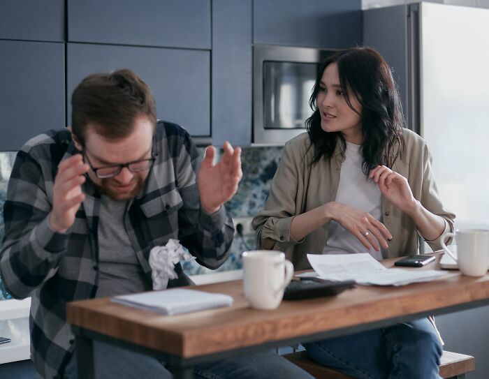A man looking distressed with a woman talking across a table, depicting the moment her boyfriend said something she could never come back from.
