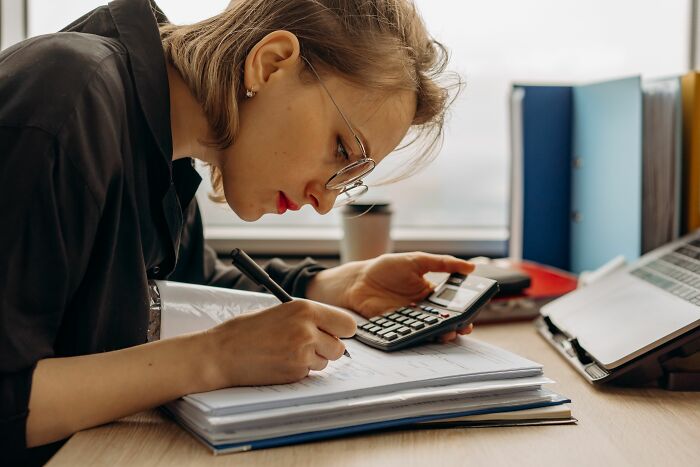 A woman working on calculations, showcasing incredible accomplishments and dedication.