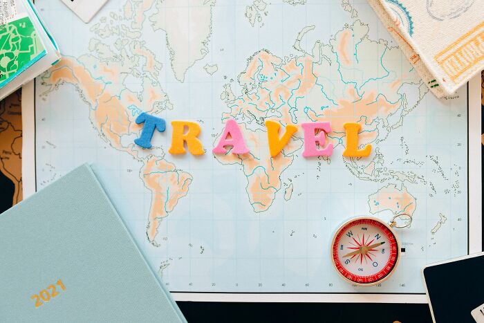 A world map with the word TRAVEL spelled out in colorful letters, symbolizing shocking employee stories and HR.