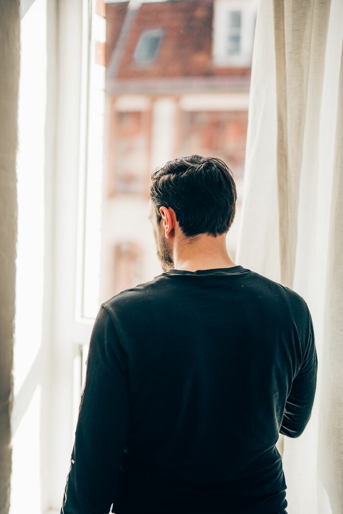 A man looks out a window, contemplating earning mad respect for sick burns.