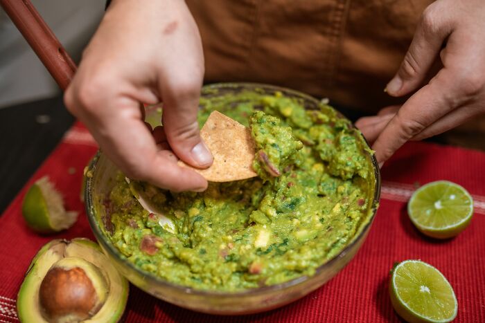 Newcomers in America enjoy fresh guacamole with tortilla chips, a surprising and delicious American food.