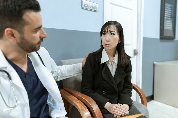 A medical field worker comforts a patient in a waiting room. The support from medical field workers is crucial.