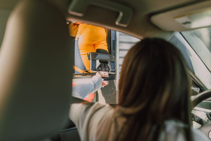 A customer hands an employee a credit card at a drive-through window, hearing crazy things customers said.