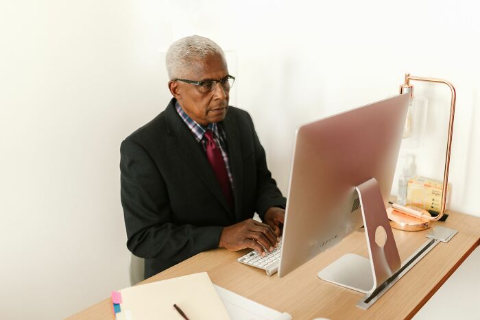 An HR pro diligently working on a computer, likely reviewing employee stories and potential reasons for firing.