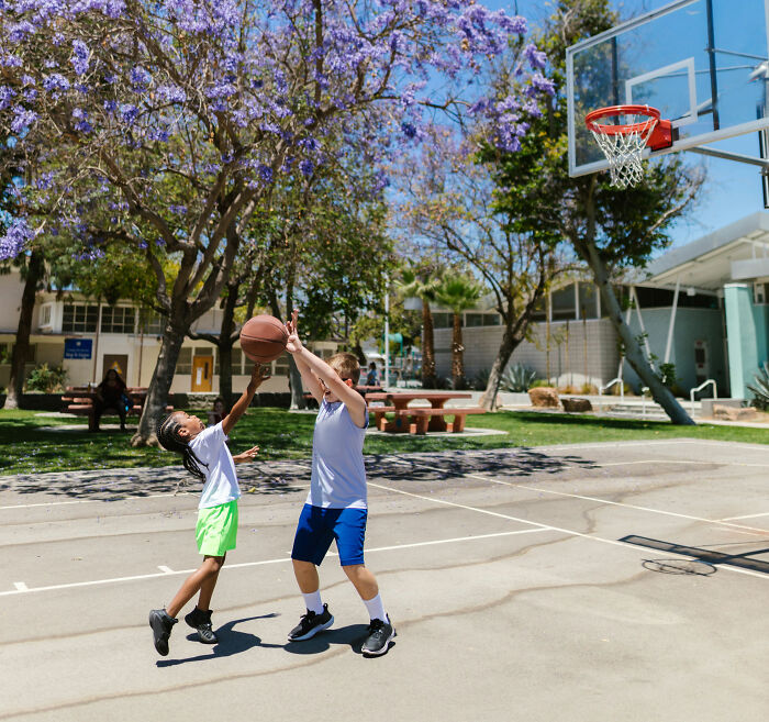Children playing basketball at school, highlighting different kid's school lunch experiences in France vs USA. Children playing basketball at school, highlighting different kid's school lunch experiences in France vs USA.