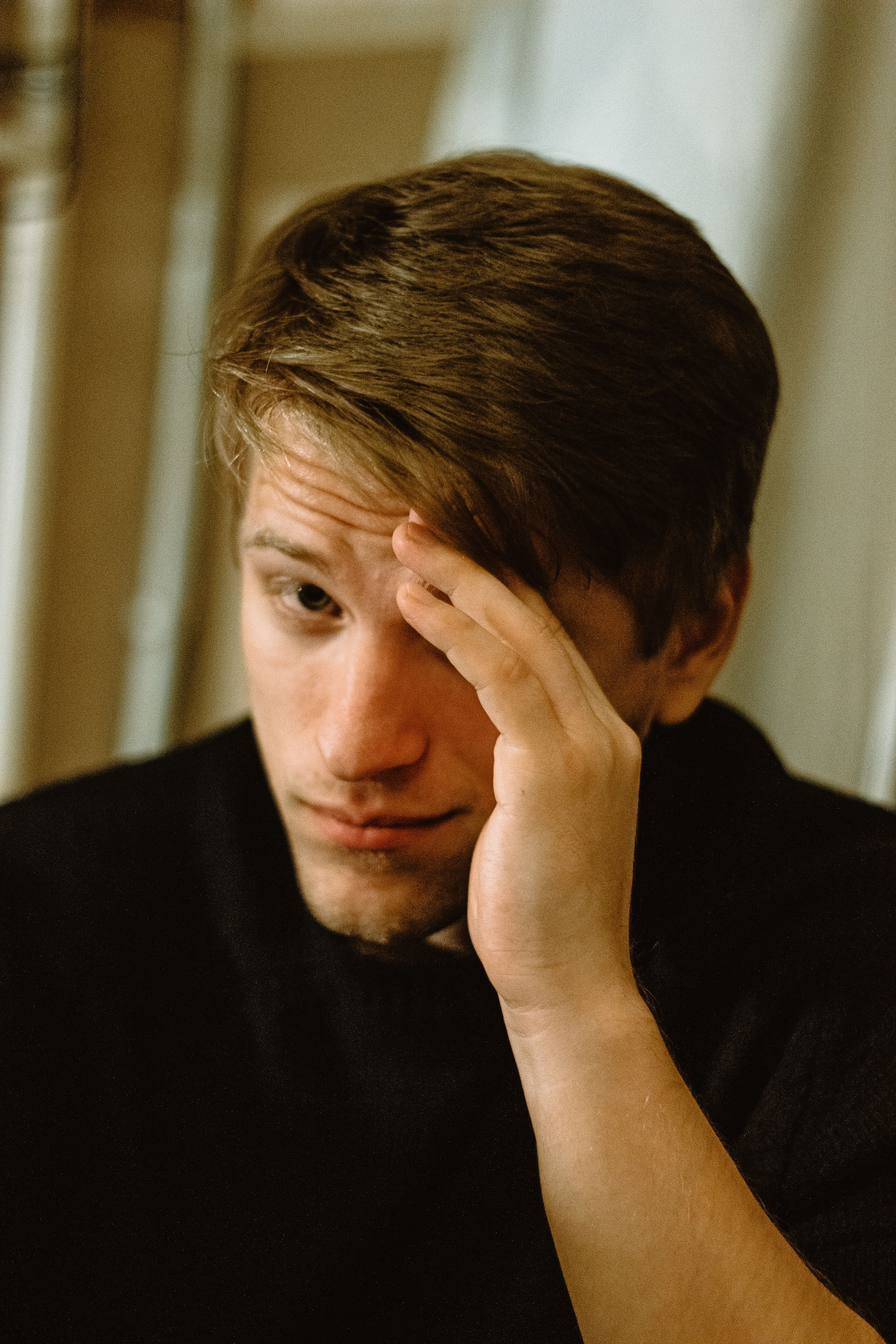 A homeowner looking stressed, covering part of his face, after receiving an HOA fine. A homeowner looking stressed, covering part of his face, after receiving an HOA fine.