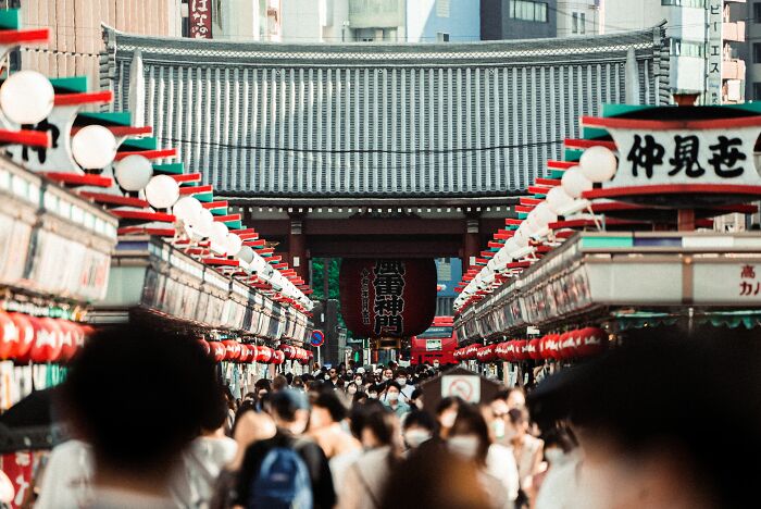 A bustling street market in front of a temple, full of people, representing widespread misconceptions.