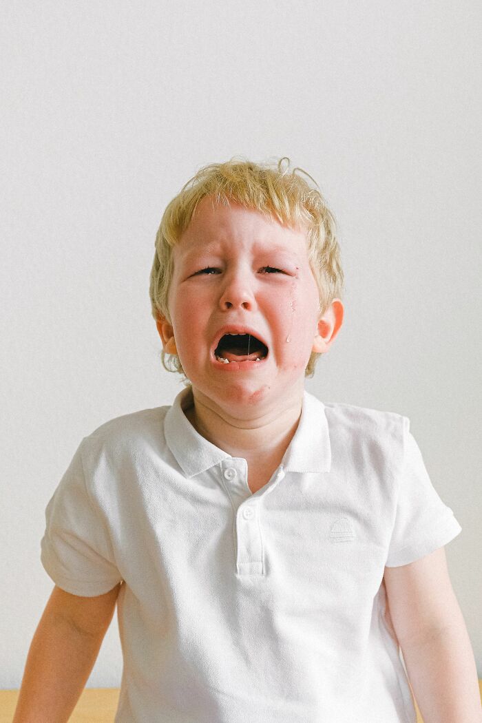 A young boy crying, representing the emotional impact of a boyfriend saying something hurtful.