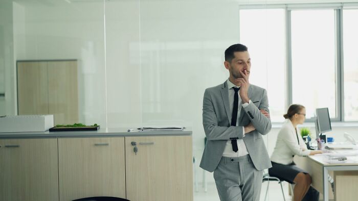 A thoughtful employee contemplating HR issues, reflecting on employee stories that could lead to being fired.