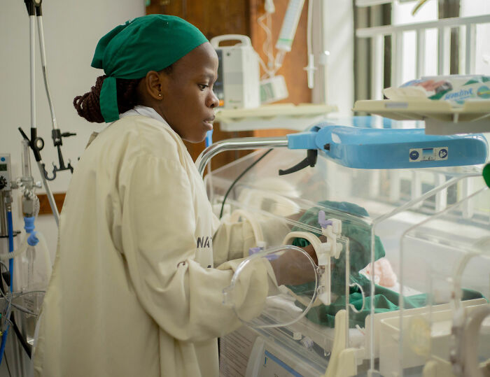 A healthcare professional tending to a baby in an incubator, relating to accidental married cousin advice. A healthcare professional tending to a baby in an incubator, relating to accidental married cousin advice.