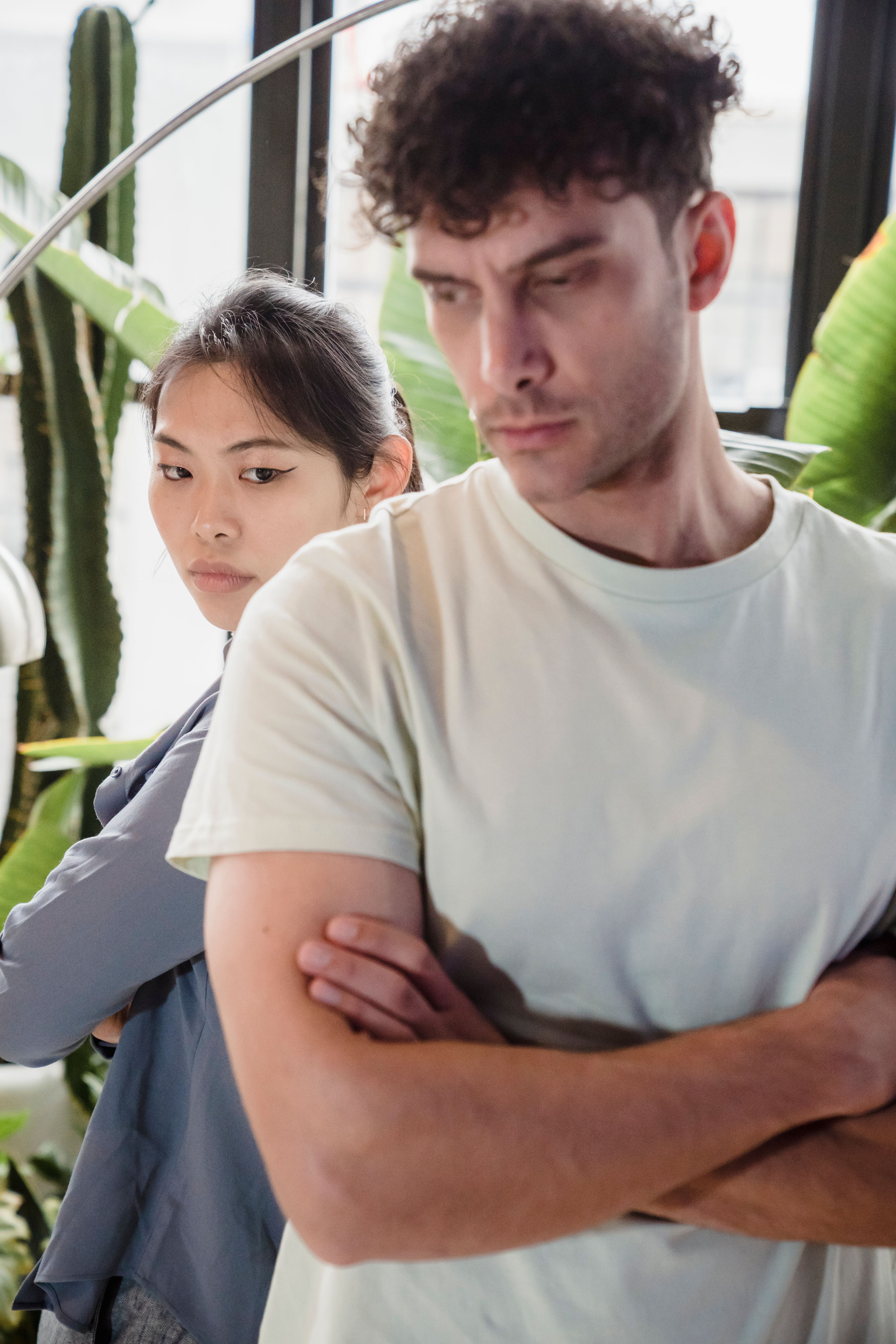 A man and his fiancée look away from each other, arms crossed, reflecting the conflict over the fancy laptop. A man and his fiancée look away from each other, arms crossed, reflecting the conflict over the fancy laptop.
