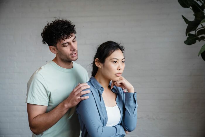 A man trying to comfort a woman who looks upset, illustrating relationship red flags and mental health concerns.