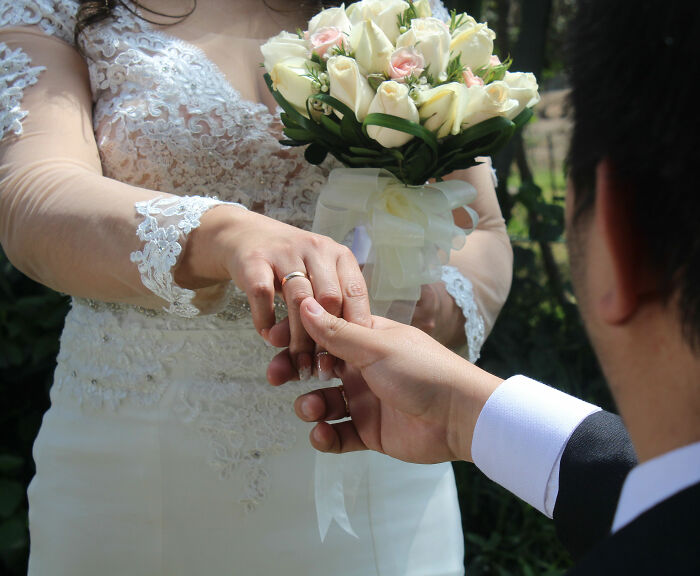 A close-up of a man putting a wedding ring on his cousin's finger, as he accidentally married her. A close-up of a man putting a wedding ring on his cousin's finger, as he accidentally married her.