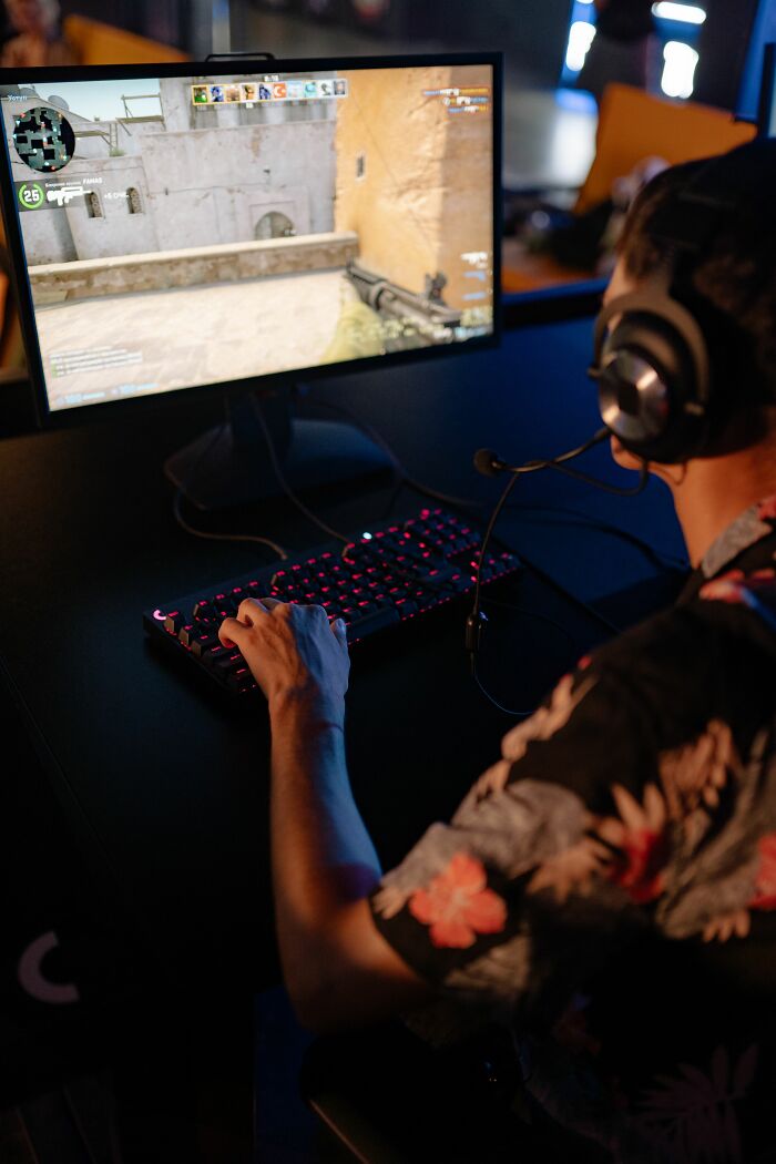 Person playing a video game on a computer, highlighting misconceptions about screen time or gaming.