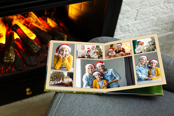 A photo album open to images of happy families, with a fireplace in the background, a MIL image.
