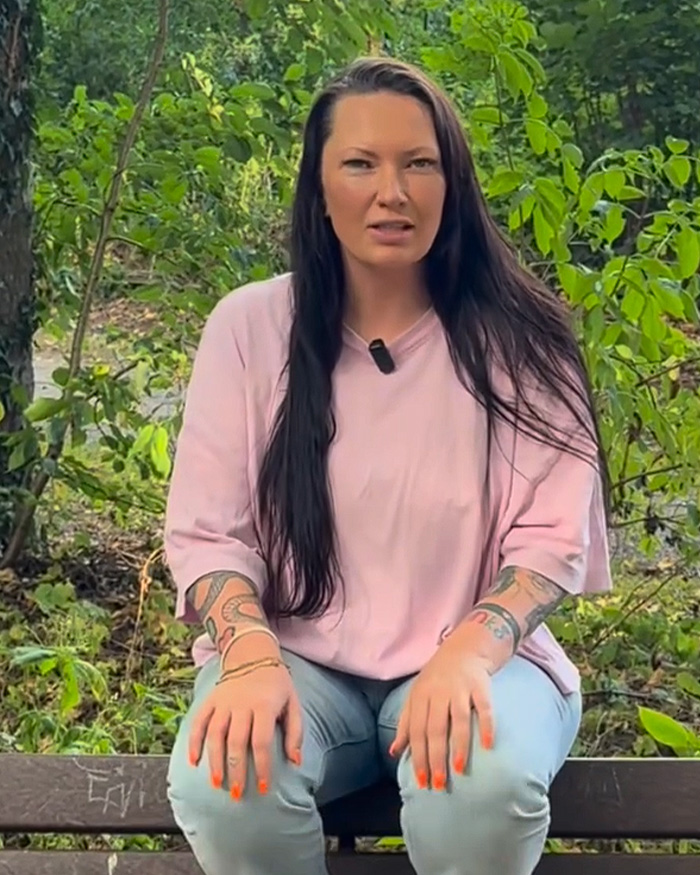 A Conservative politician sits outdoors, wearing a pink shirt, with her provocative necklace visible for her campaign poster. A Conservative politician sits outdoors, wearing a pink shirt, with her provocative necklace visible for her campaign poster.
