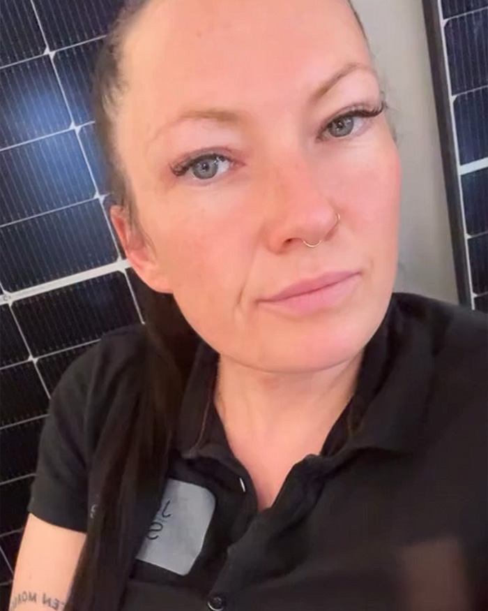 A politician refusing to remove a provocative necklace, expressing identity beyond being a mom, set against solar panels. A politician refusing to remove a provocative necklace, expressing identity beyond being a mom, set against solar panels.