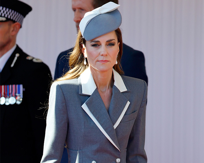 Kate Middleton in a grey and white outfit with a matching hat, looking directly ahead. King Charles, Queen Camilla.