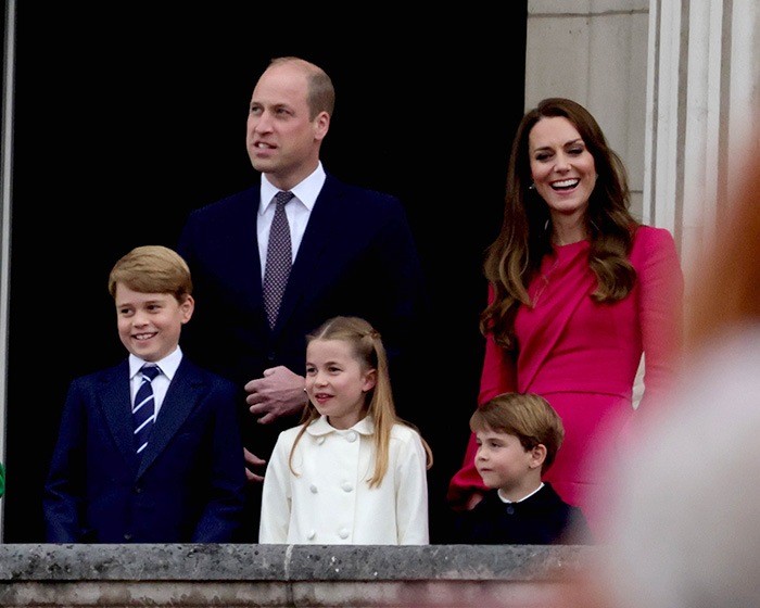 Prince William and Kate Middleton with their children, facing the crowd, possibly after a name change.