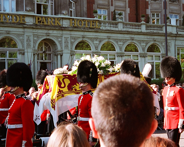 A somber royal funeral procession for Princess Diana, with a flag-draped coffin passing the Hyde Park Hotel. A somber royal funeral procession for Princess Diana, with a flag-draped coffin passing the Hyde Park Hotel.